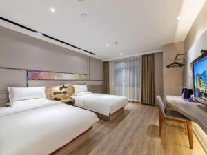 a hotel room with two beds and a flat screen tv at Starway Hotel (xiamen zhongshan road) in Xiamen +85 photos
