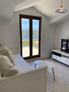 Un dormitorio con una cama, un televisor y una mesa. en Appartment with a view in Necujam, en Nečujam