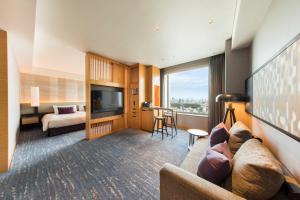 a living room with a couch and a television at Cerulean Tower Tokyu Hotel, A Pan Pacific Partner Hotel in Tokyo