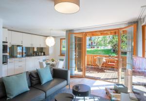a kitchen and living room with a couch and a table at Panoramapark Soleil Chalet C in Wengen