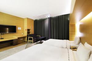 a hotel room with two beds and a flat screen tv at Business Design Hotel LUV in Incheon