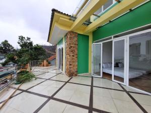 una casa con una pared verde y un balcón en Top Hill Halong Homestay 3 phòng nghỉ riêng, en Ha Long