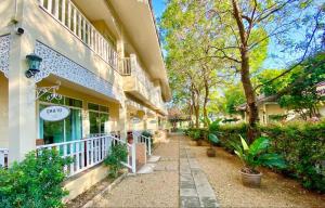 a building with a porch with plants and trees at Ruen Maihom Riverside Cottage in Ban Tha Nam Tun