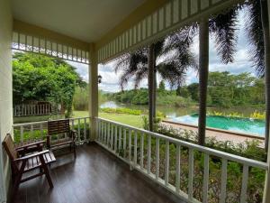 a screened in porch with a view of a swimming pool at Ruen Maihom Riverside Cottage in Ban Tha Nam Tun