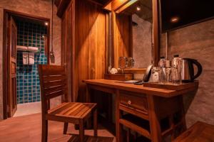 a bathroom with a sink and a counter with a mirror at Ruean Racha in Chiang Mai