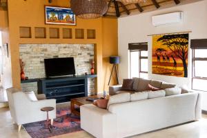 a living room with a couch and a fireplace at Afrikaya Bush Lodge in Hoedspruit