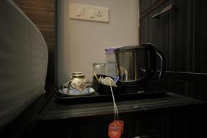 a coffee maker sitting on a counter next to a coffee pot at Nirvana Rooms near Mall Road in Shimla