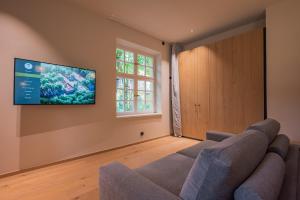 a living room with two chairs and a flat screen tv at Gutshotel Menterschwaige in Munich