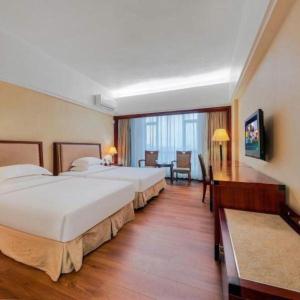 une chambre d'hôtel avec deux lits, une table et des chaises dans l'établissement Borrman Hotel Dongguan Changping Avenue, à Dongguan 147 autres photos