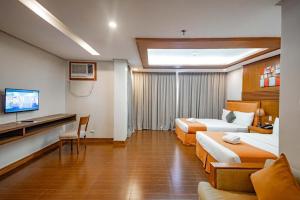 a hotel room with two beds and a flat screen tv at Subic Grand Harbour Hotel Subic Bay in Olongapo
