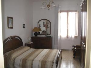 a bedroom with a bed and a mirror and a window at Appartamento Vacanze in Stintino