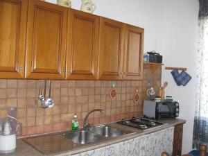 a kitchen with a sink and a microwave at Appartamento Vacanze in Stintino