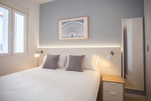 a white bedroom with a white bed and a window at Apartment in Malasaña in Madrid