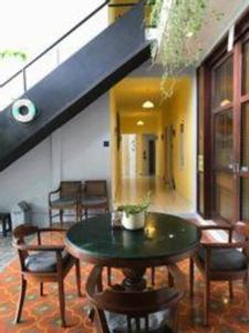 a room with a table and chairs and a staircase at Matta Lodge Bali in Jimbaran