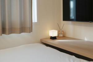 a bedroom with a bed with a lamp and a tv at OFF STAY, hotel in Seoul - 10m from Airport, 8m to Subway in Seoul