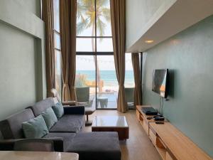un soggiorno con un divano e una grande finestra di Eco Cozy Beachfront Resort Chaam a Hua Hin