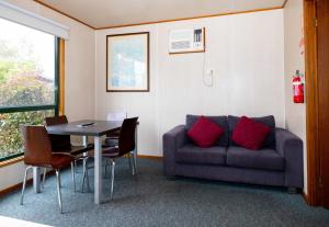 a living room with a couch and a table at Airport Tourist Village Melbourne in Melbourne