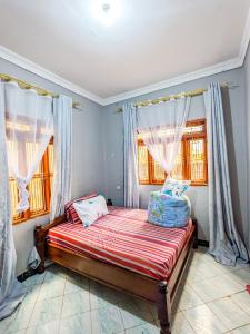 ムベヤにあるKaribu Jua Backpackers Hostelの窓のある部屋にベッドがある寝室