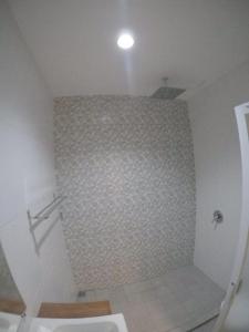 a bathroom with a shower with a tiled wall at Satria Wisata Hotel in Parepare +71 photos
