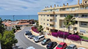 a street with cars parked in front of a building at CANDESUN APARTMENT*** in Cala del Moral