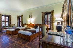 a bedroom with two beds and a table with a table sidx sidx sidx at Godavari Village Resort in Kathmandu +36 photos