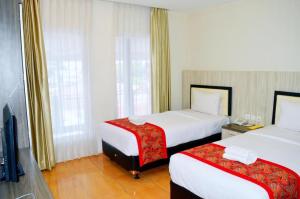 a hotel room with two beds and a television at Grant Hotel Subang in Bandung +68 photos