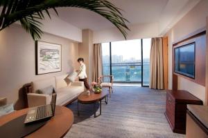 a person standing in a living room with a couch at Great International Hotel in Heyuan