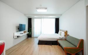 sypialnia z łóżkiem, kanapą i telewizorem w obiekcie Swansea Resort w mieście Czedżu