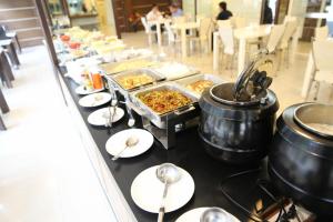 a buffet line with dishes and pots and pans of food at The Residence Prachinburi in Si Maha Phot