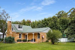 a brick house with a green roof at Studio Cottage Alpine Southern Highlands in Alpine