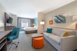 a hotel room with a couch and a bed at Comfort Suites in French Lick