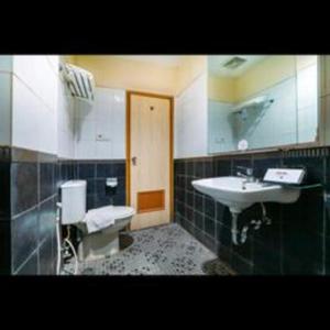 a bathroom with a sink and a mirror at Hotel Marlin Pekalongan Managed by Dafam in Pekalongan
