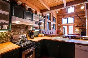 a kitchen with black cabinets and a stove top oven at Mt Baker Rim Cabin #44 - Hot Tub- Pets Ok - Wifi in Glacier