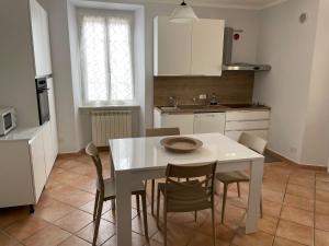 a kitchen with a white table and chairs in it at Il Marasio, relax vicino al mare in Carrara
