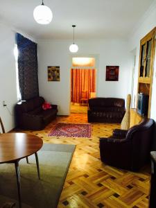 sala de estar con muebles de cuero y suelo de madera en GuestHouse Natali, en Telavi