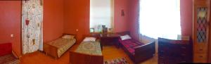 a room with two beds and a table and a window at GuestHouse Natali in Telavi