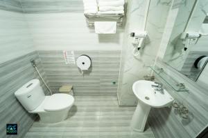 a white bathroom with a toilet and a sink at Cao Bang Eco Bistro & Stay in Cao Bằng +39 photos