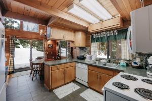a kitchen with wooden cabinets and a large window at Mt Baker Rim Cabin 53 - Hot Tub - Wi-Fi - Bbq in Glacier +16 photos