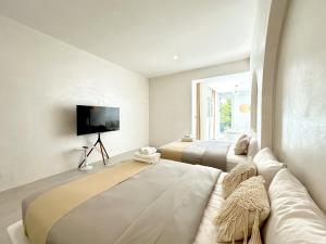 a living room with a couch and a tv at Evelia Kohsamed in Ao Phutsa