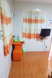 une pièce avec un bureau et une télévision dans une pièce dans l'établissement OYO 75352 Hotel Family House And Resort Phetchaburi, à Ban Lahan Bon 42 autres photos