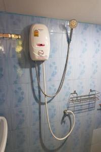 La salle de bains est pourvue d'une douche et d'un distributeur de savon sur le mur. dans l'établissement OYO 75352 Hotel Family House And Resort Phetchaburi, à Ban Lahan Bon