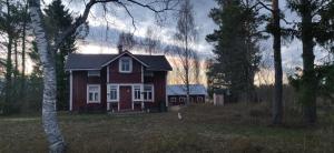 una casa roja en medio de un bosque en Villa Kotipelto, en Sievi