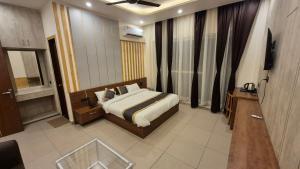 a hotel room with a bed and a television at The Corbett Green Woods in Rāmnagar