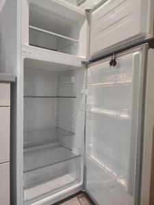 an empty refrigerator with its door open in a kitchen at Meraki Skopelos in Skopelos Town