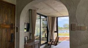 a bedroom with a bed and a large window at Thalia Boutique Hotel Hoian in Hoi An