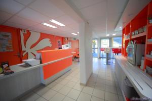 a fast food restaurant with an orange wall at Premiere Classe Ales - Anduze in Alès