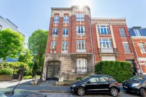 a building with two cars parked in front of it at Spacious 3 bedrooms apartement 135 m & privative parking in Lille