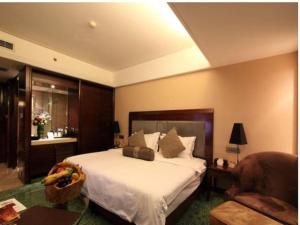 a bedroom with a large white bed and a couch at Yiwu Hyde Jianguo Hotel in Yiwu