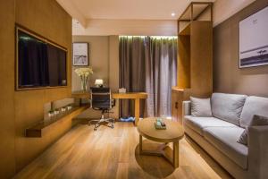 a living room with a couch and a table at V8 Ziyuangang Hotel in Guangzhou