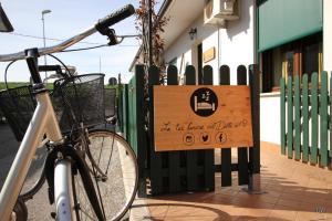 a bike parked next to a sign on a fence at Oasi di Arcadia in Santa Giulia
